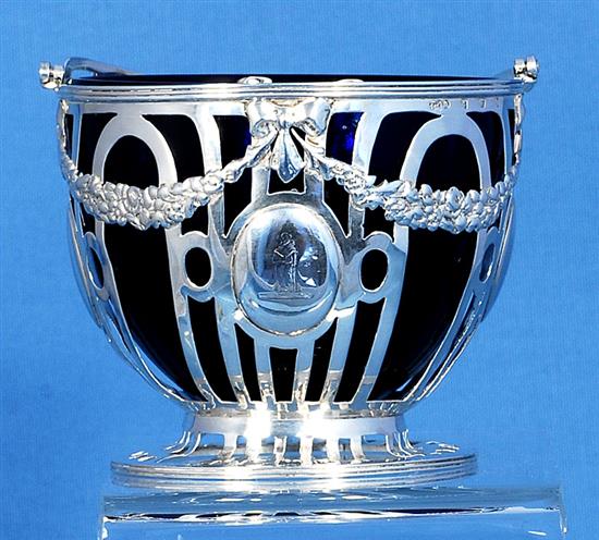 An Edwardian pierced silver sugar basket and blue glass liner, Height to handle 6”/155mm Dia 104mm Weight Silver only: 5.1oz/145grms